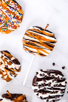 caramel, chocolate and sprinkle covered apple lollipops on a stick