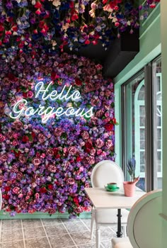 the inside of a restaurant with flowers on the wall and tables in front of it