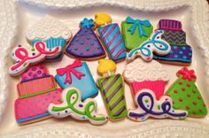 decorated cookies in the shape of birthday hats and gifts on a white platter, ready to be eaten