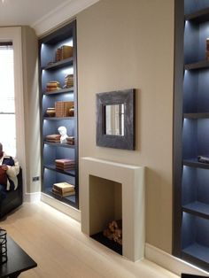 a man sitting on a couch in front of a fire place with bookshelves