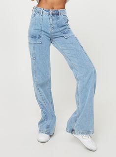 a woman in high waist jeans is posing for the camera