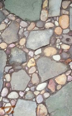 a close up view of a stone floor with many different colors and shapes on it