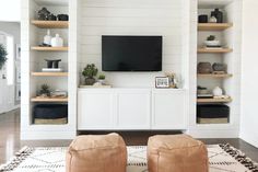 two brown chairs sitting in front of a flat screen tv