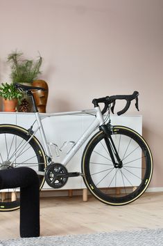 a bike is parked next to a white cabinet