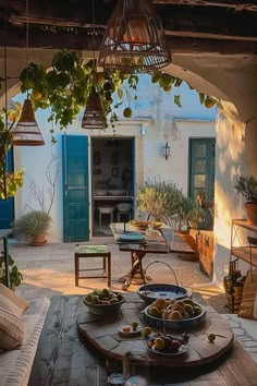 an outdoor dining area with fruit on the table and potted trees in the background