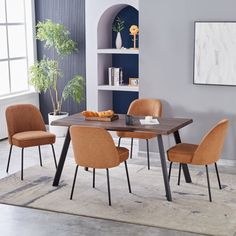 a dining room table with four chairs and a rug on the floor in front of it