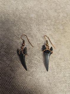 pair of earrings with black stone and gold plated earwires on grey fabric