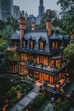 a large house with lots of windows and lights on it's roof, surrounded by greenery