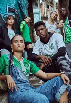 a group of young people sitting next to each other on the steps in front of a building