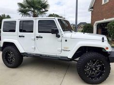 a white jeep parked in front of a house