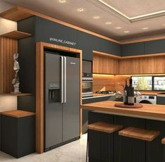 a modern kitchen with wooden cabinets and stainless steel refrigerator freezer, counter tops, and stools