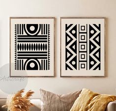 two black and white art prints hanging on the wall above a couch in a living room