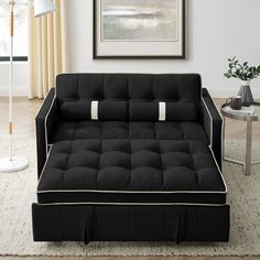 a black and white couch sitting on top of a rug