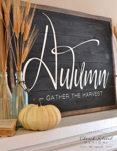 a wooden sign that says autumn, gather the harvest on top of a mantel