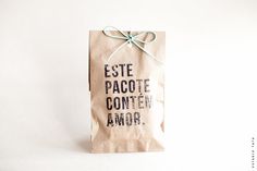 a brown paper bag tied up with a green ribbon and the words este pacote conten amor on it