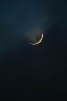 the moon is seen through the clouds in the night sky, with only one light visible