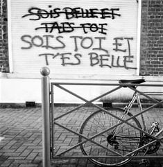 a bicycle locked to a gate with graffiti on it