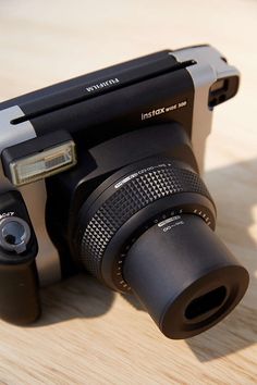 a black camera sitting on top of a wooden table