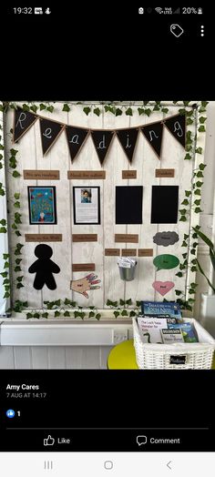 a bulletin board with pictures on it and some plants in the back ground next to it