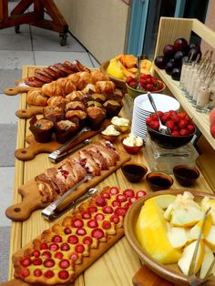 an assortment of fruits and pastries on a table with bread, jams, fruit