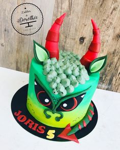 a green and red cake with horns on it