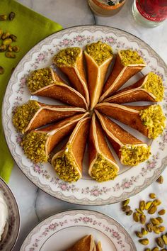 there are several desserts on the plates and one has pistachio sauce in it