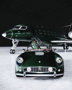 an old fashioned car is parked in front of a small plane with the pilot inside