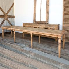 a wooden table sitting on top of a hard wood floor next to a dresser and mirror