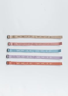 four different colored leather bracelets with the word wild written on them in gold, silver, and pink