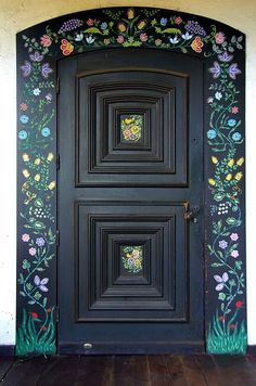 a black door with flowers painted on it