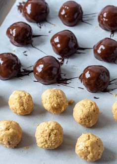 chocolate covered donuts are lined up on a sheet of parchment paper and ready to be baked