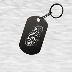 a dog tag with music notes on it and a keychain hanging from the side