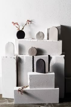 several white and black vases on top of cement blocks