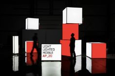 a man standing in front of red and white cubes with the words light lighted mobile ap 20