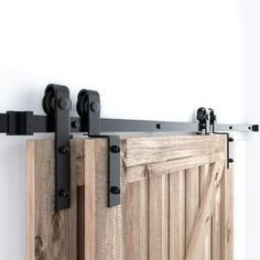 an open wooden door with black hardware on the top and bottom bars attached to it