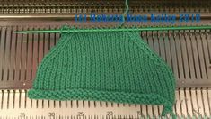 a green knitted apron hanging on a metal grate with measuring tape next to it