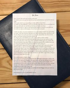 a piece of paper sitting on top of a wooden table next to a black folder