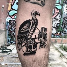 a man's leg with a bird on top of a skull and cacti