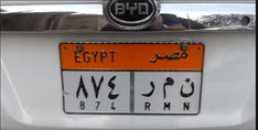 an orange and white license plate on the back of a car with egyptian writing in arabic