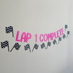 a banner that says lap 1 complete with checkered flags hanging from the wall next to it