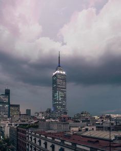 a city skyline with tall buildings and cloudy skies