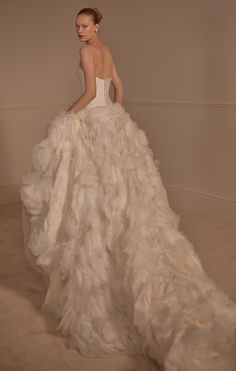 a woman in a wedding dress is standing on the floor with her back to the camera