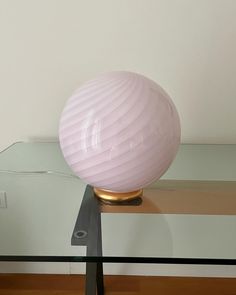 a pink lamp sitting on top of a glass table