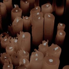 many lit candles are lined up in rows