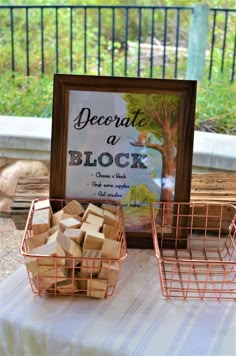 a table topped with baskets filled with blocks of wood next to a sign that reads, become a block