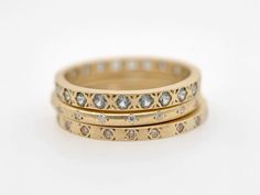 three gold wedding bands with diamonds on each band, set in 18k yellow gold