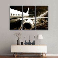 an airplane on the runway in black and white with three panels above it that are hanging on a wall