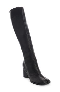 Inspired by the Japanese tabi sock, this iconic split-toe boot is updated in a knee-high silhouette and set on a monochromatic cylindrical heel. 3" (80mm) heel (size 10) 16" shaft Side zip closure Leather upper, lining and sole Made in Italy SPACE: A shop for emerging and advanced designers Knee High Tabi Boots, Split Toe Boots, Dream Items, Tabi Boots, Tabi Socks, Maison Margiela Tabi, Margiela Tabi, High Knees, Fabric Gift Bags