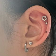 an ear with three small stars on the top and one smaller star on the bottom