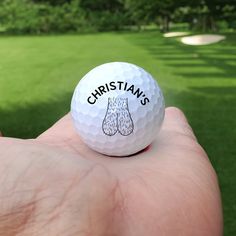 a person holding a golf ball with the word christianans on it in their hand